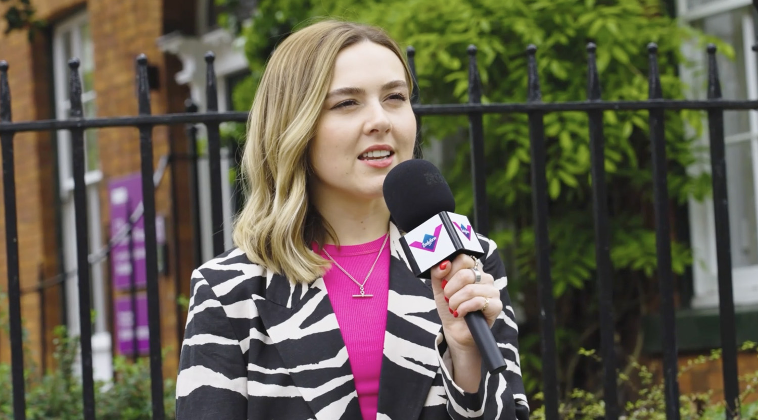 Presenter holding a branded microphone during a street interview