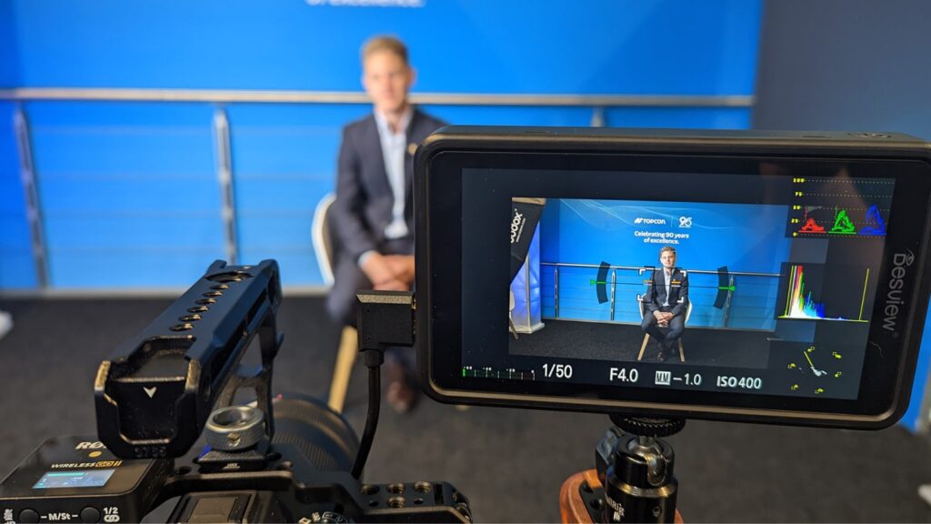 Camera filming a speaker on stage at a B2B trade event