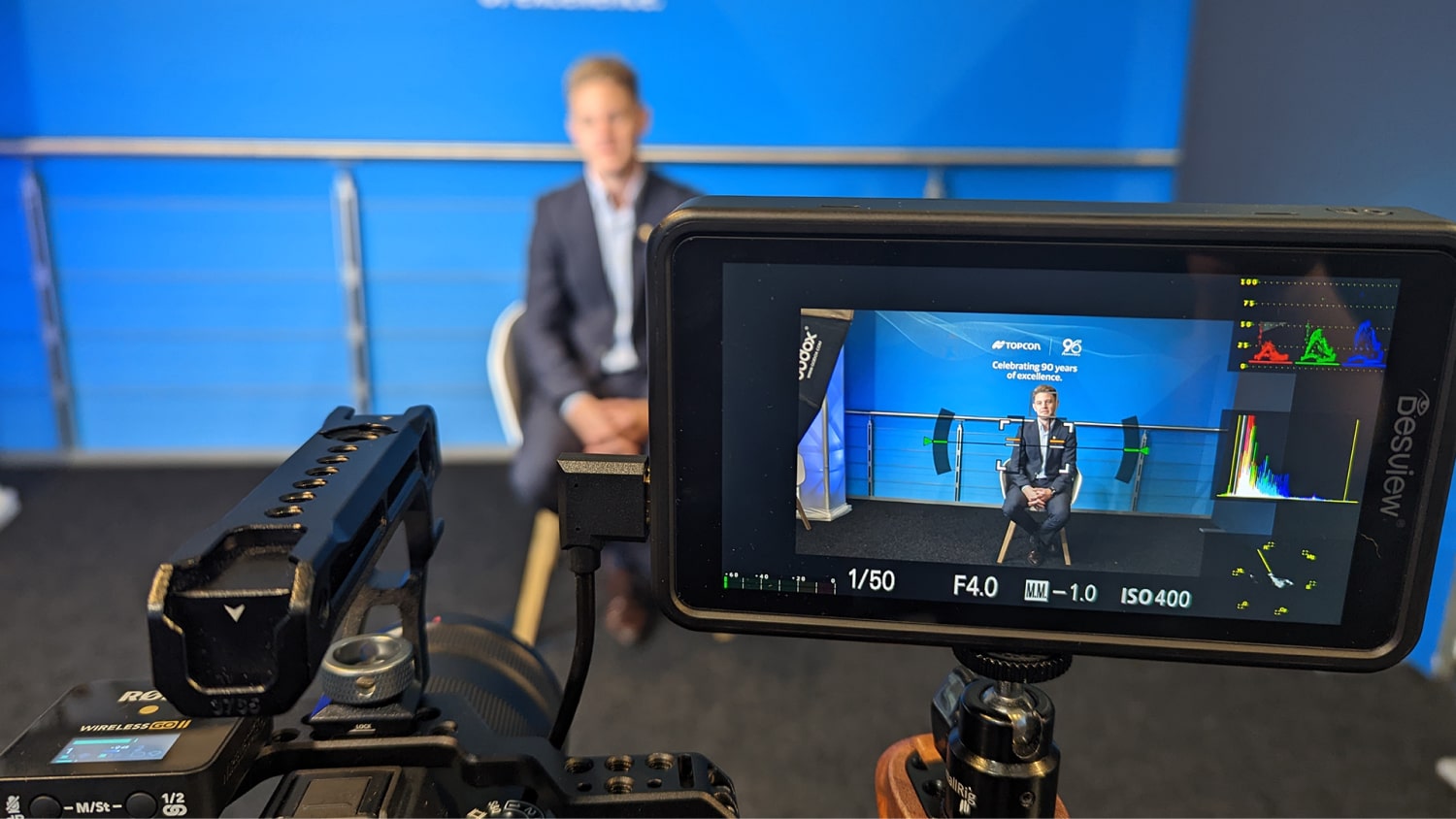 Camera filming a speaker on stage at a B2B trade event