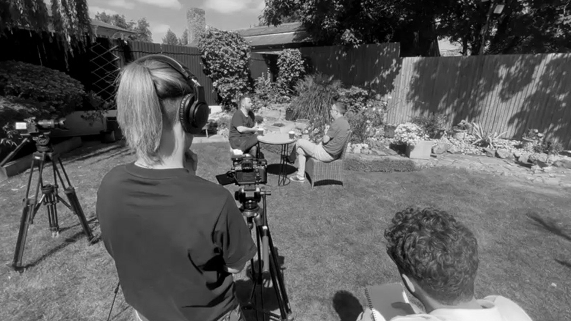 Film crew recording an interview in a garden