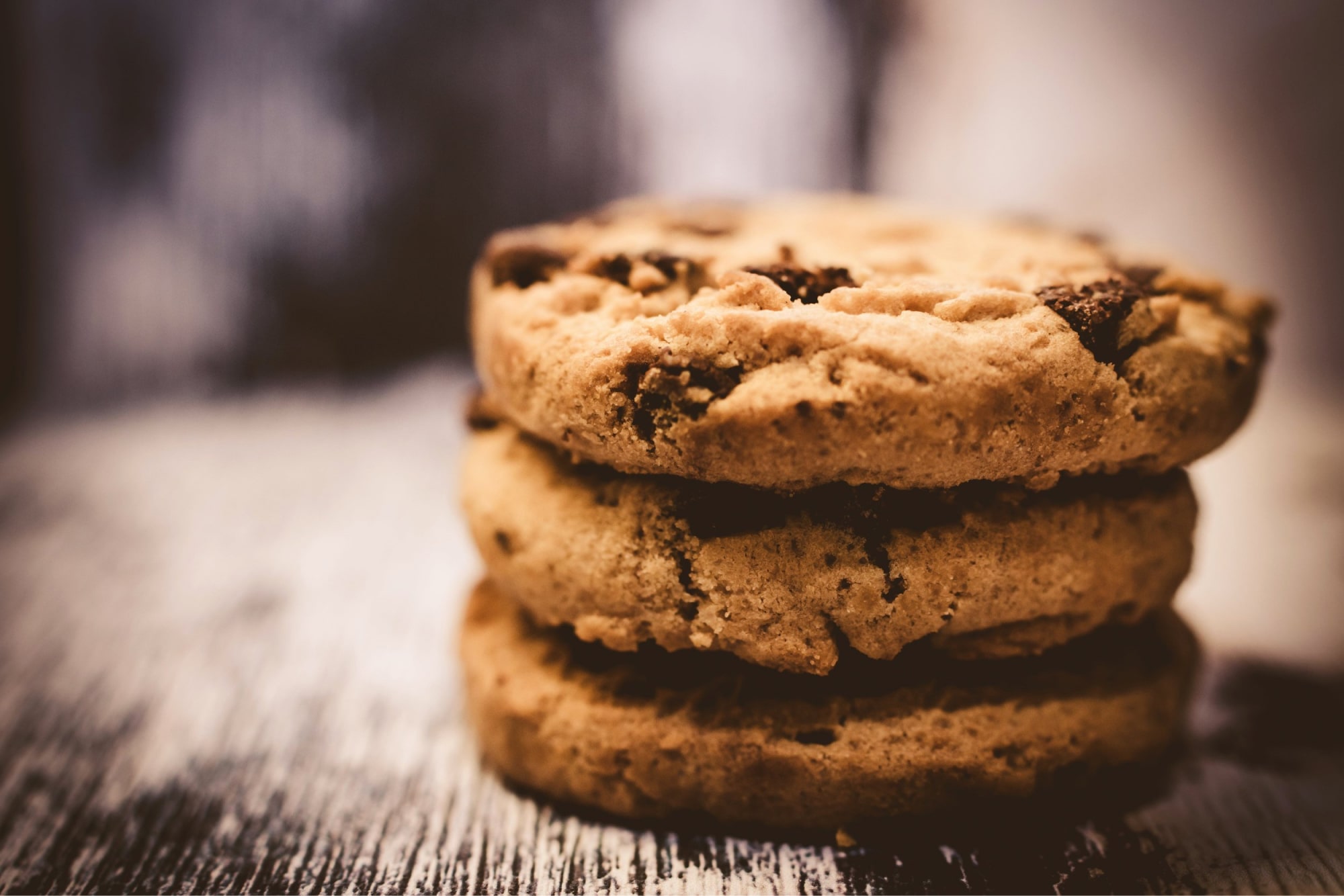 Stack of chocolate chip cookies on a wooden table, illustrating the end of third-party cookies