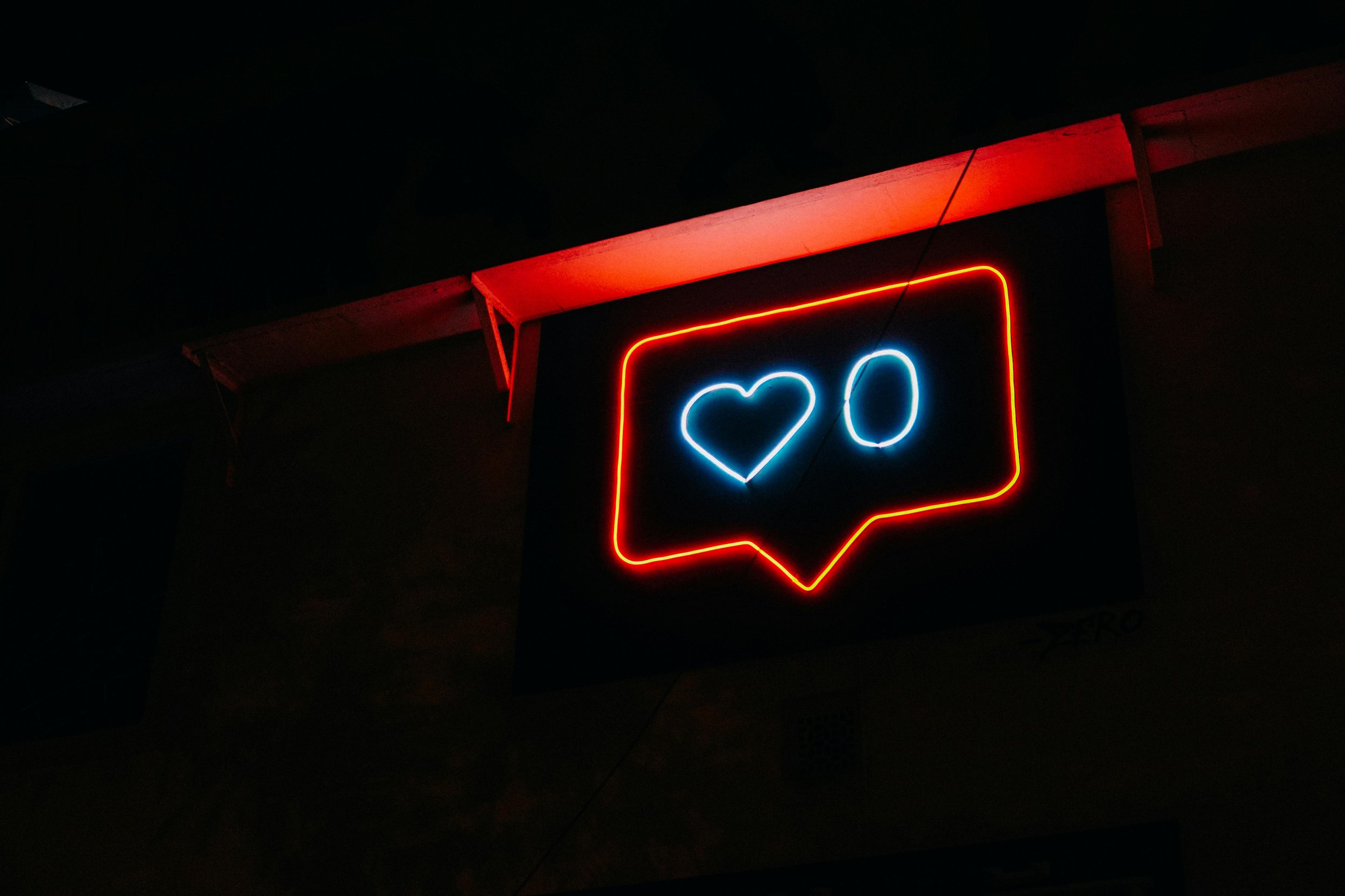 Neon sign showing a like heart with a zero count