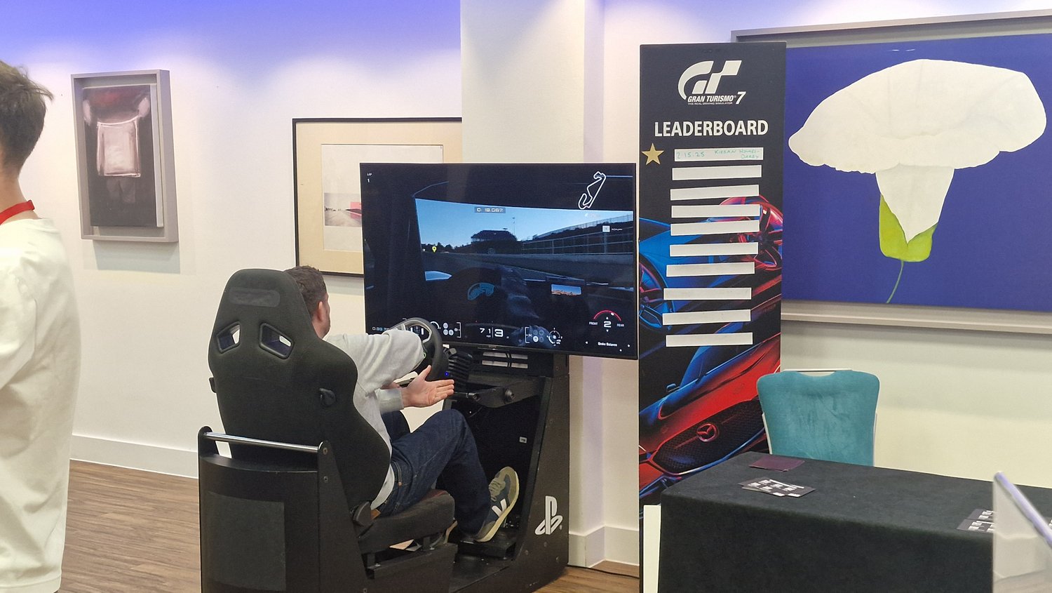 Visitor trying a Gran Turismo racing simulator at Campaign's Gaming Summit