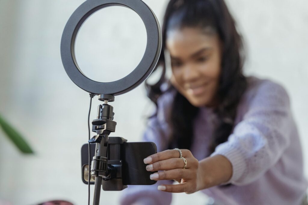 Content creator setting up a smartphone on a ring light to film