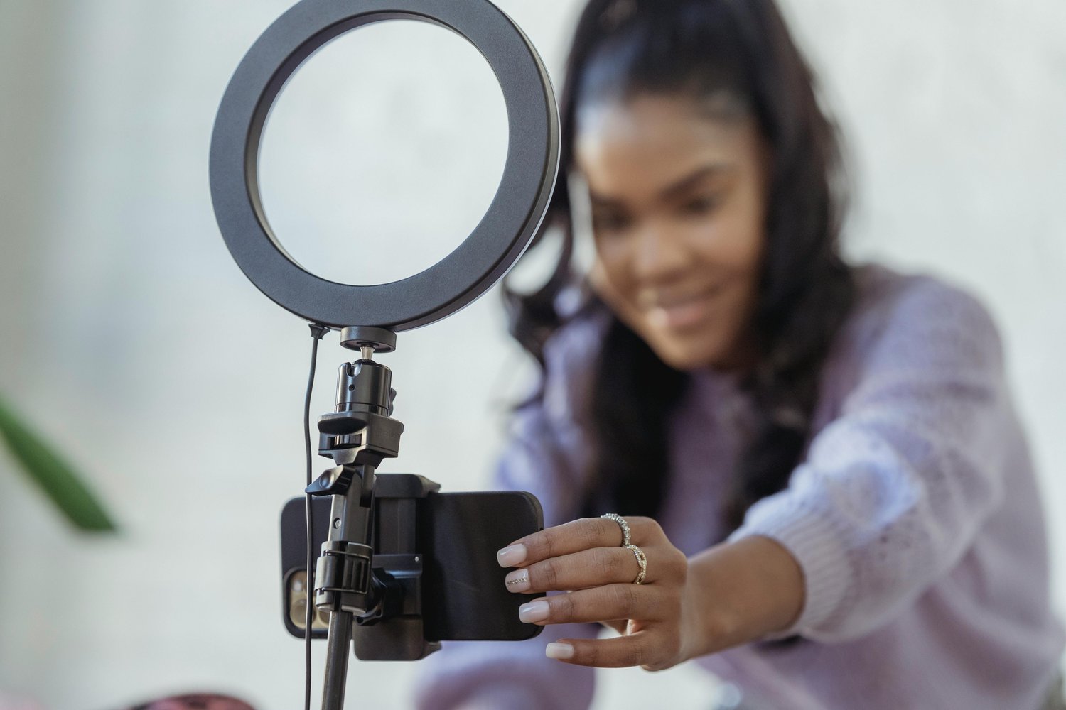 Content creator setting up a smartphone on a ring light to film