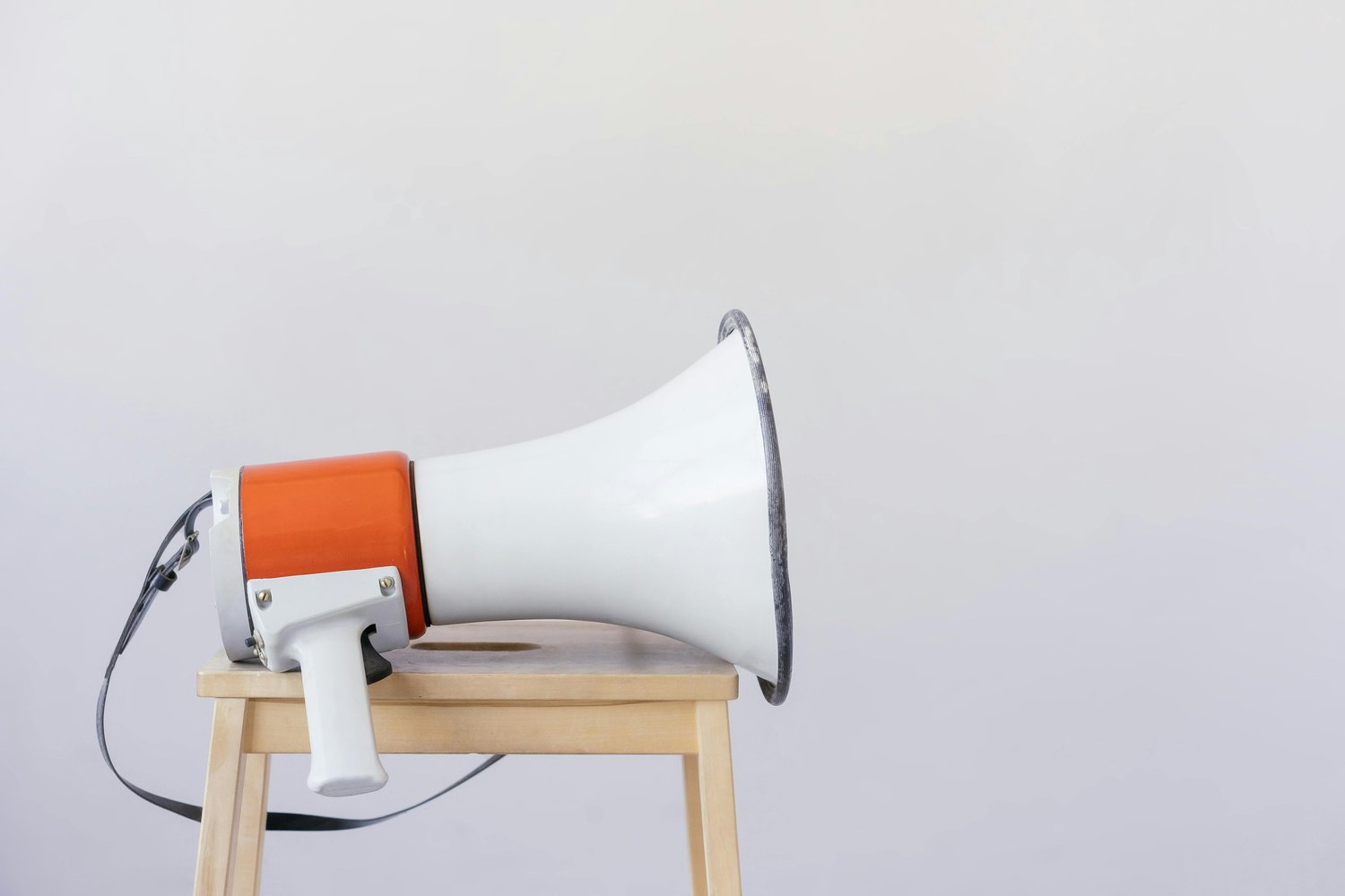 White and orange megaphone on a wooden stool
