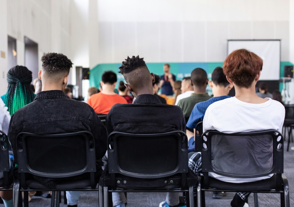 Apprentices seated in rows listening to a speaker in a training room
