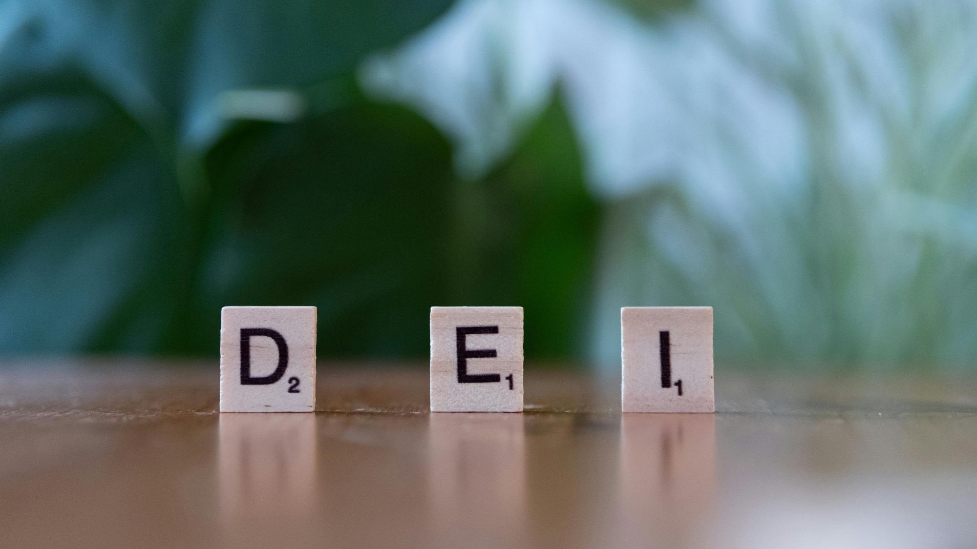 Scrabble tiles spelling DEI on a table