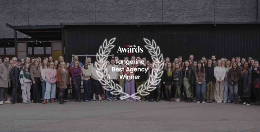 Tangerine team group photo outdoors with a PRWeek Awards Best Agency winner graphic
