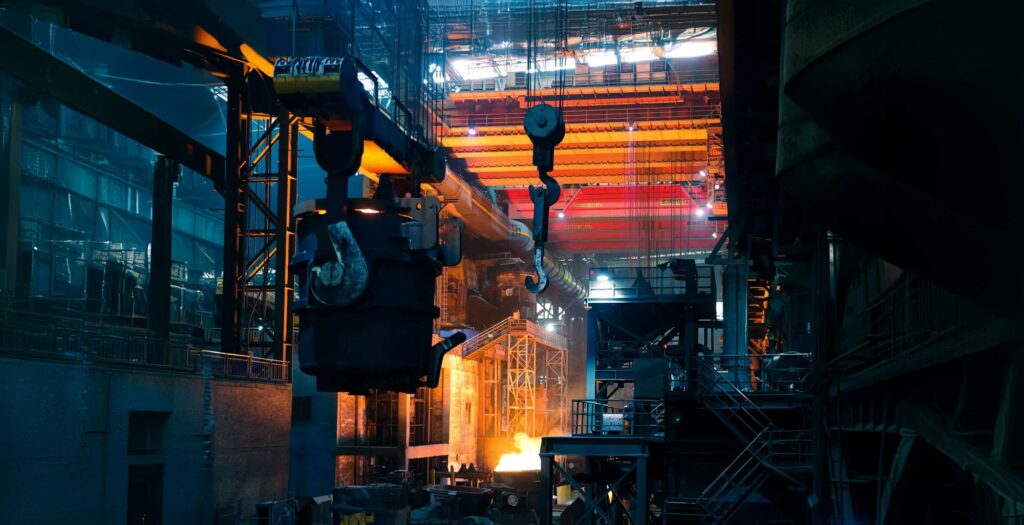 Inside a steelworks with molten metal glowing, illustrating manufacturing