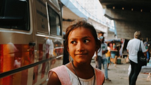 Young girl looking up on a busy street, from Tangerine's Hope Foundation film