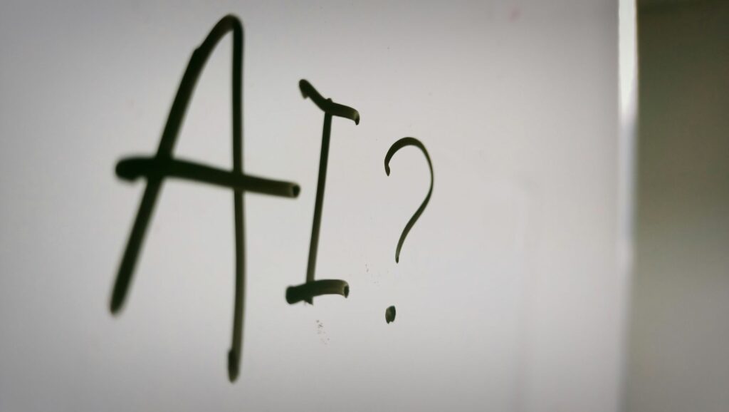 'AI?' handwritten in black marker on white paper