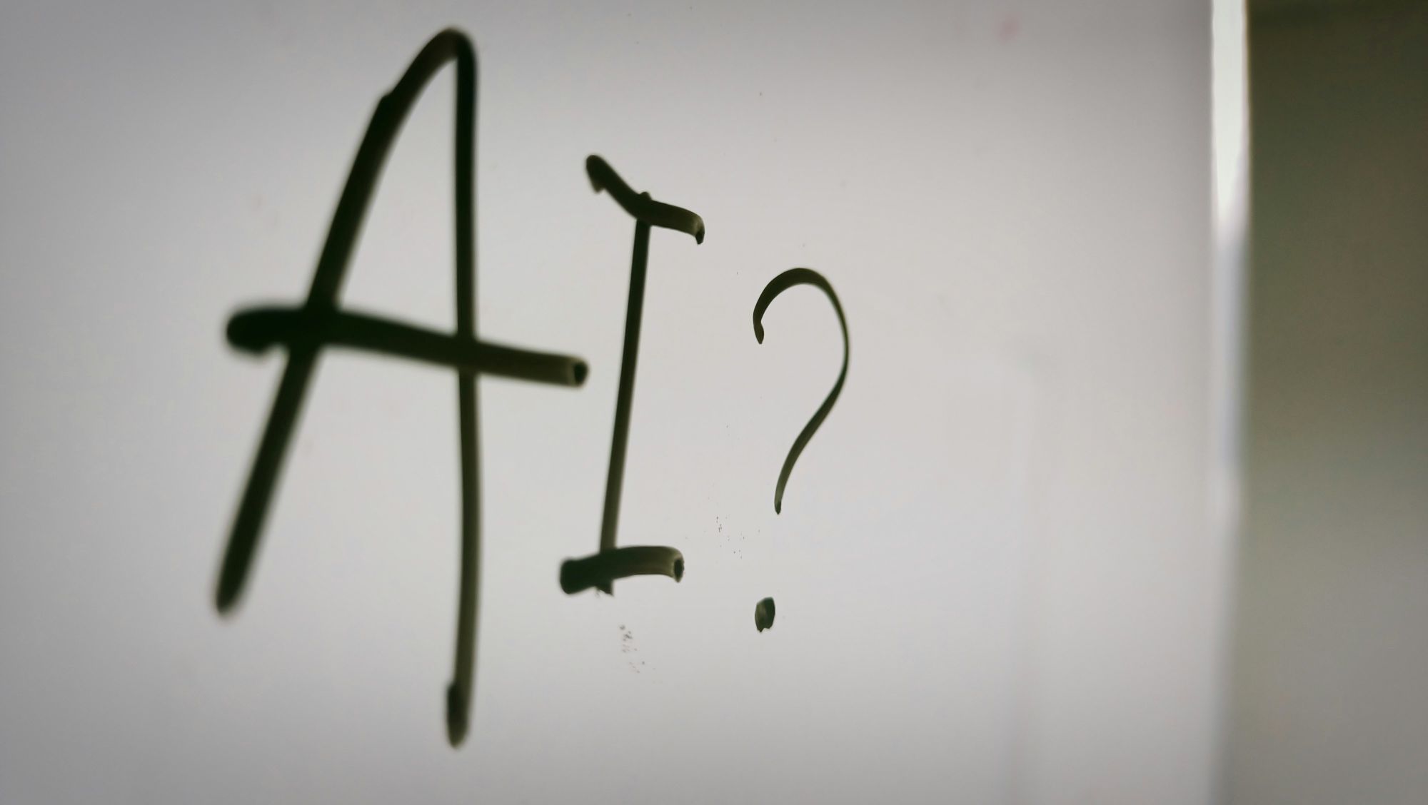 'AI?' handwritten in black marker on white paper