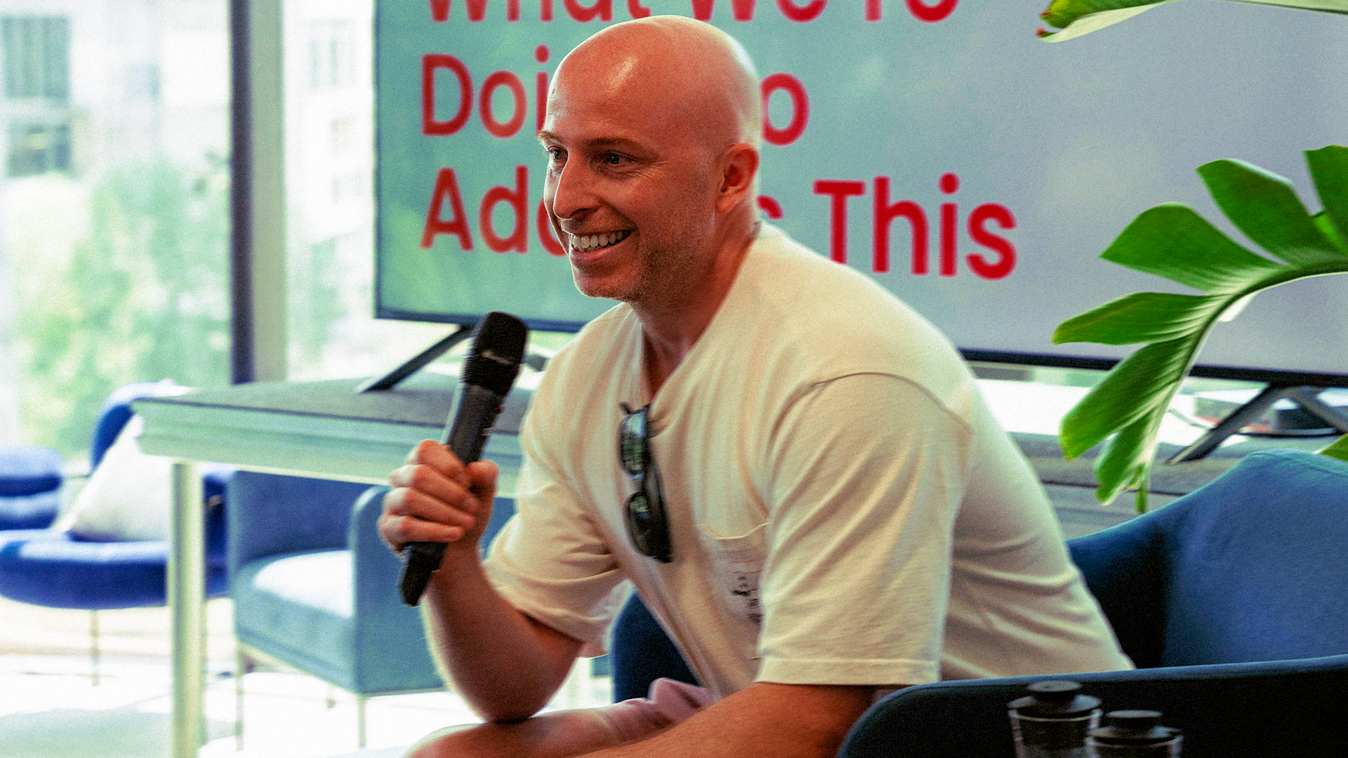 Speaker holding a microphone during a panel talk at an industry event