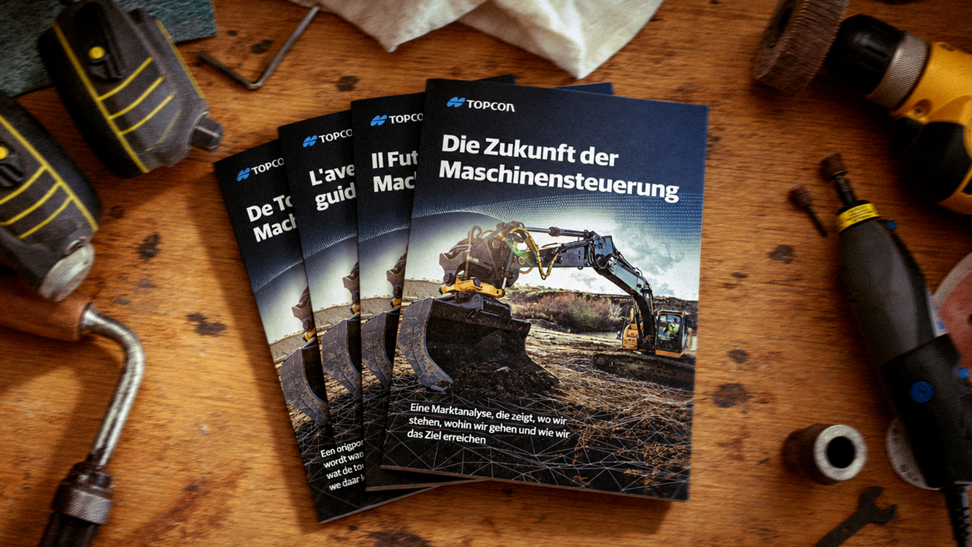 Translated editions of Topcon's 'The Future of Machine Control' report on a workbench