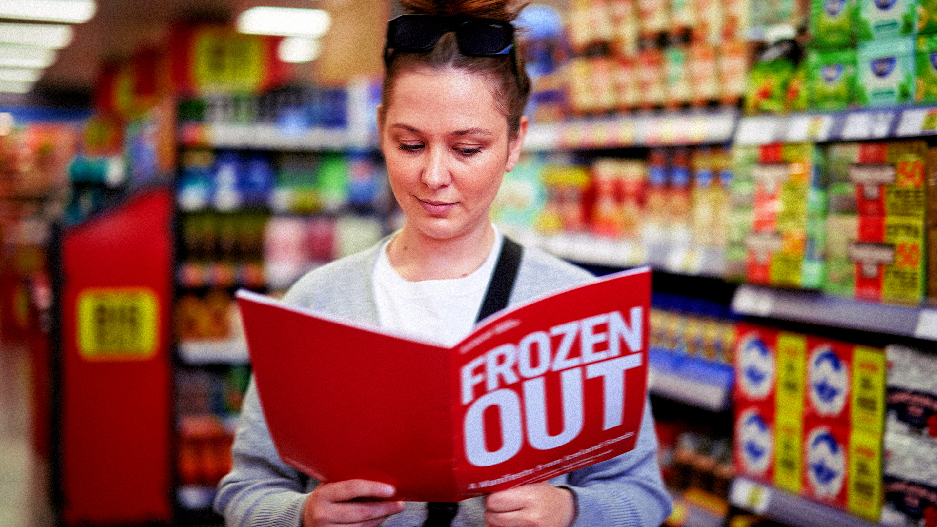 Shopper reading Iceland's 'Frozen Out' report in a supermarket aisle