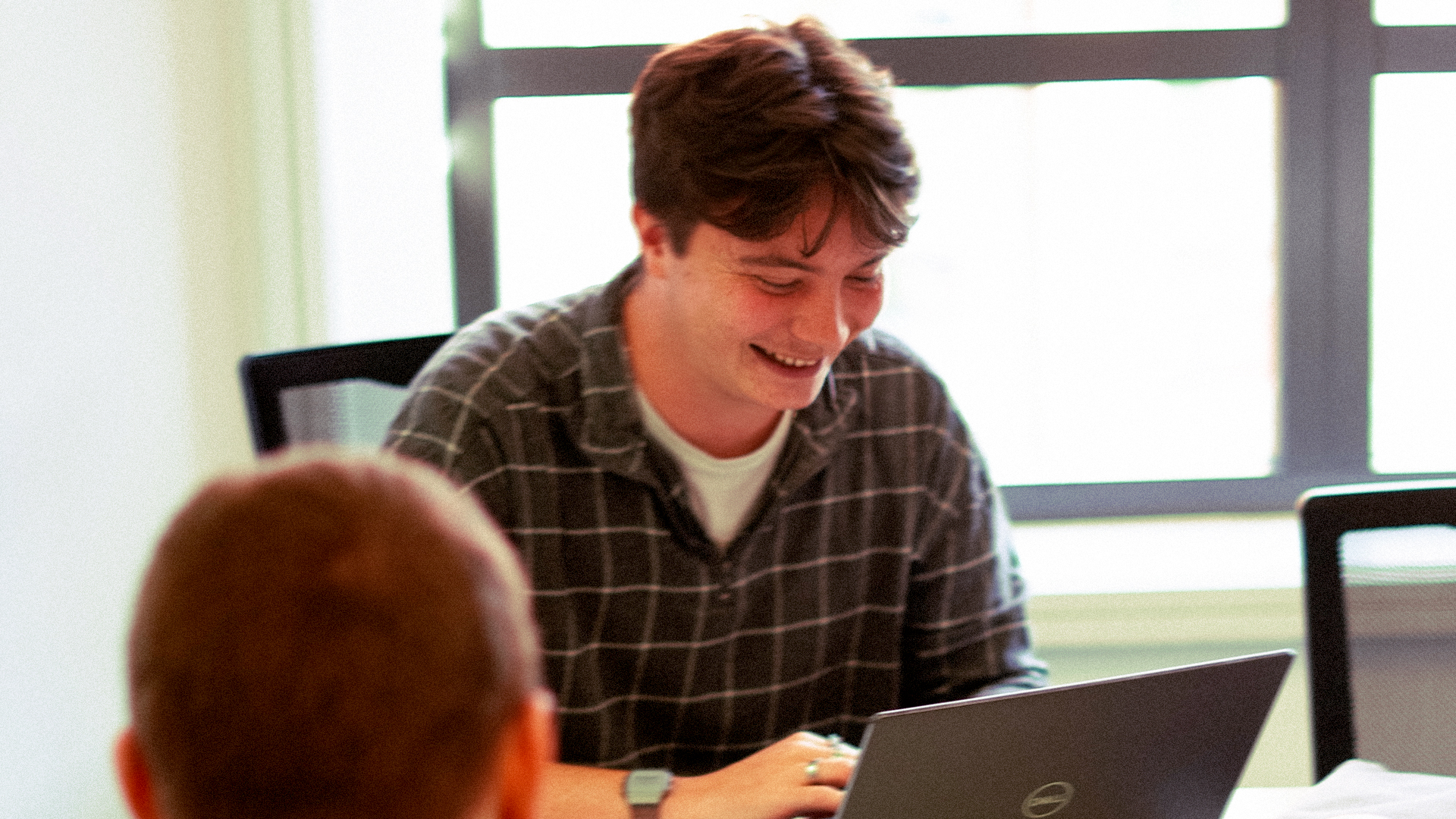 Tangerine team member smiling while working on a laptop
