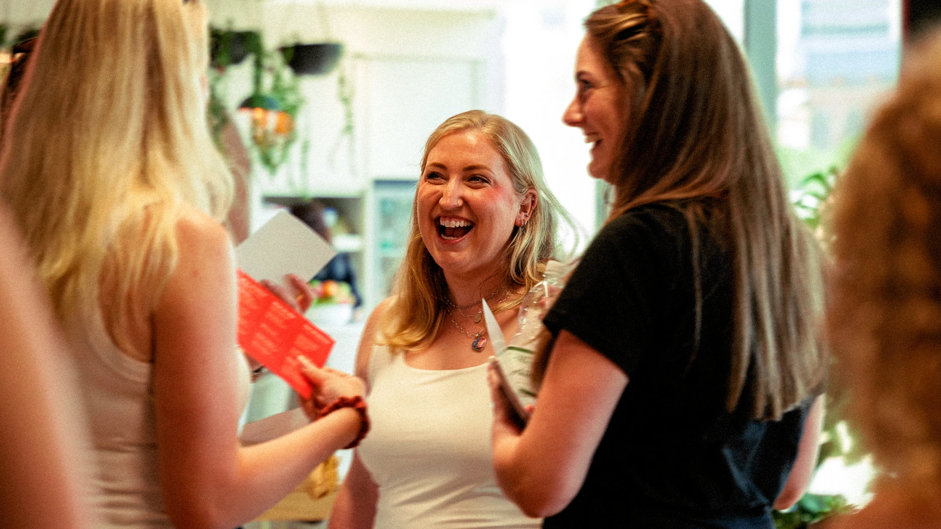 Colleagues laughing together at a Tangerine social