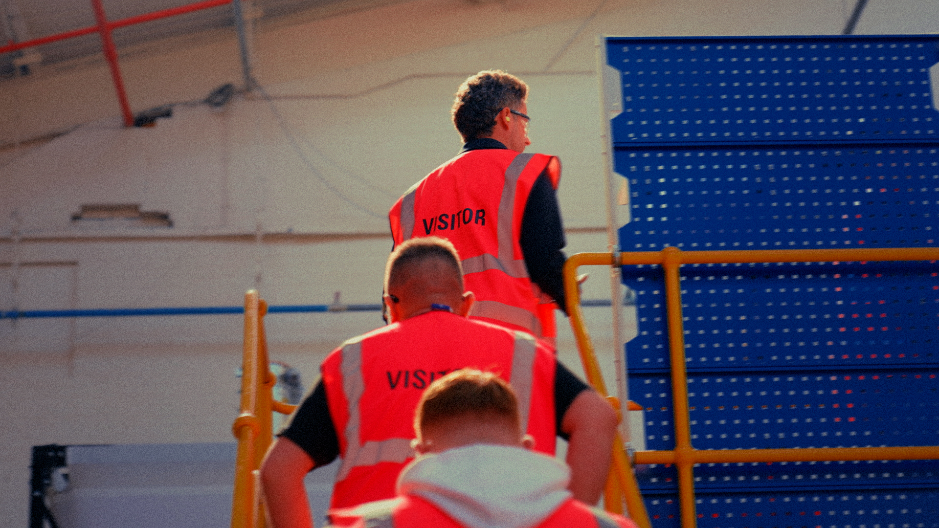 Plumbers in hi-vis vests touring a Wavin warehouse